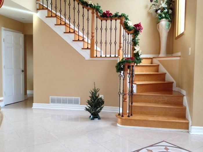 Dad-level humor with a tiny Christmas tree placed humorously beside a decorated staircase.
