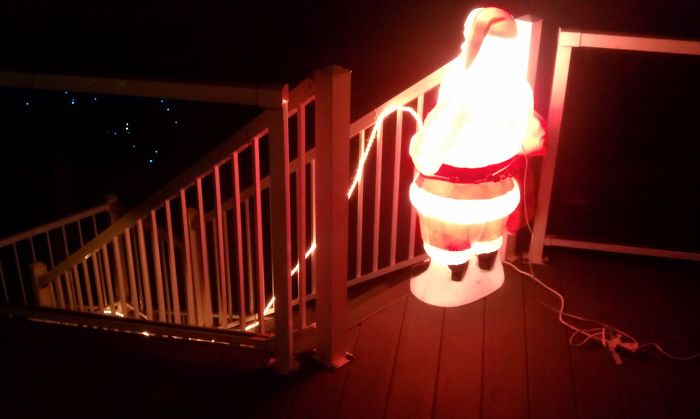 A glowing Santa placed humorously at the top of a staircase, showcasing dads' jokes at another level.