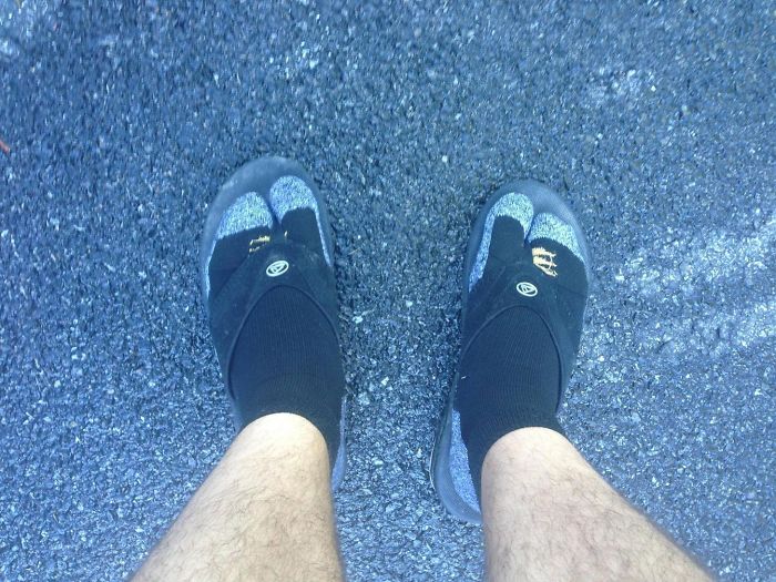 Dad humor with black socks and sandals, showing unique fashion sense on asphalt background.