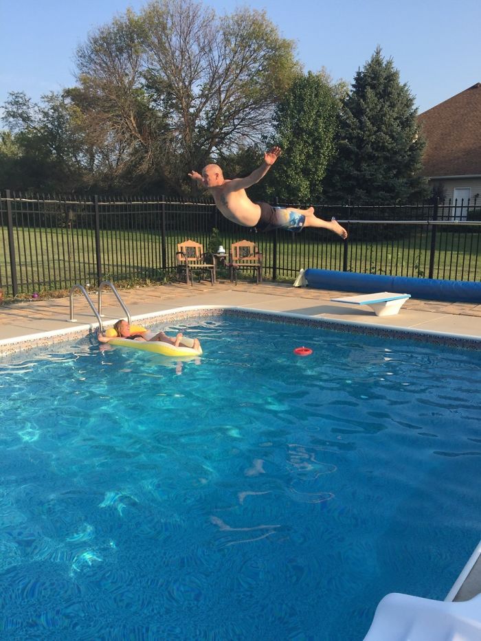 Dad mid-air over pool, about to land comically near child on float, showcasing dad jokes humor at another level.