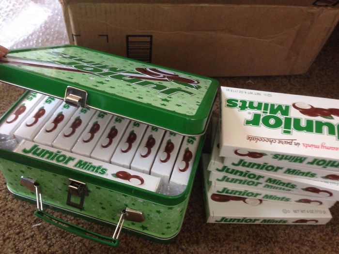 Dad joke level: Tin filled with Junior Mints boxes humorously stacked beside it.