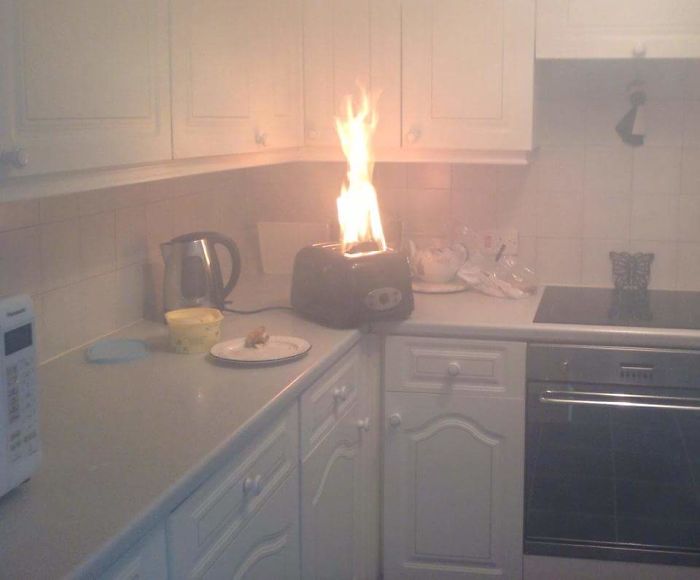 Toaster on fire in a kitchen, illustrating an extreme dad joke gone wrong.