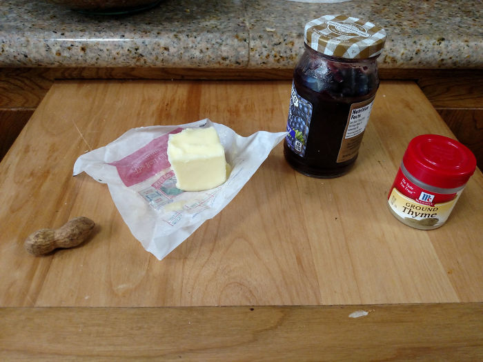 Dads take jokes to another level with a peanut, butter, jelly jar, and thyme spice on a wooden table.
