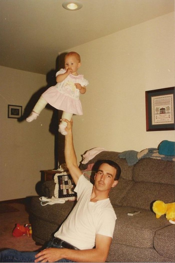 Dad balancing a baby on his hand, showcasing a playful joke taken to another level.
