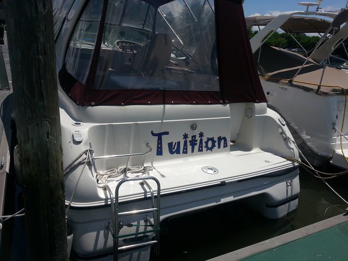 Boat labeled "Tuition" docked, showcasing a playful dad joke.