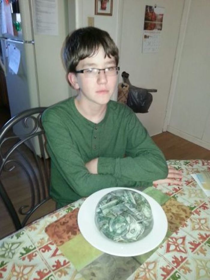 Teen sits unimpressed at table with a bowl of frozen money, exemplifying dad jokes taken to another level.