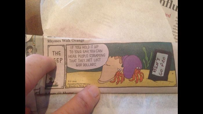 A dad holding a cartoon strip with a hermit crab joke, showcasing dad jokes on another level.