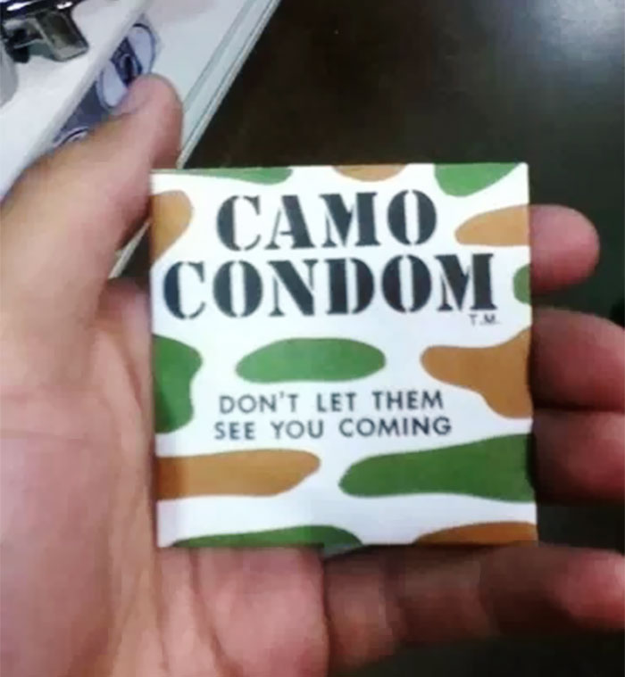 A dad holding a novelty camo c****m package, showcasing humor and creativity.