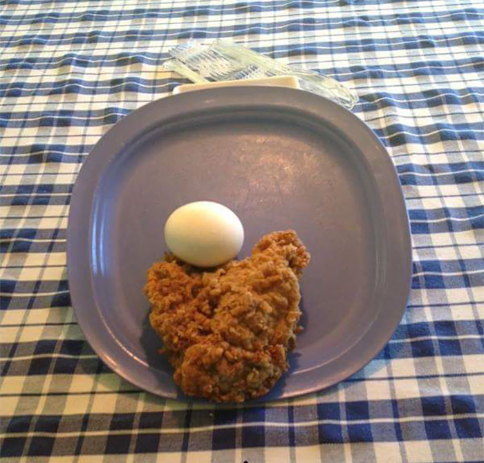 "Dad joke visual with a fried chicken piece and egg humorously arranged on a blue plate."