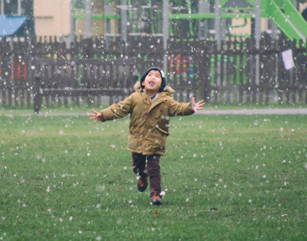 A Kid In The Park Seeing Snow For The First Time