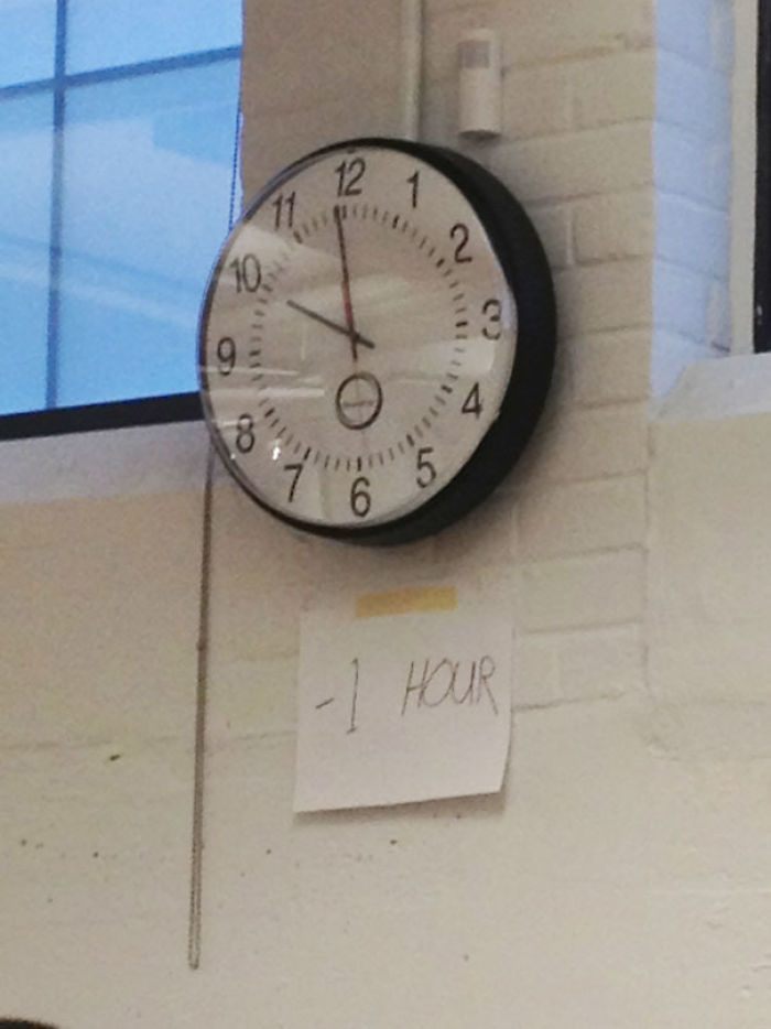 Wall clock showing incorrect time with a note saying "-1 hour," humorously highlighting indifference.