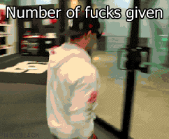 Person in a white hoodie casually walks into a glass door, showing a carefree attitude.