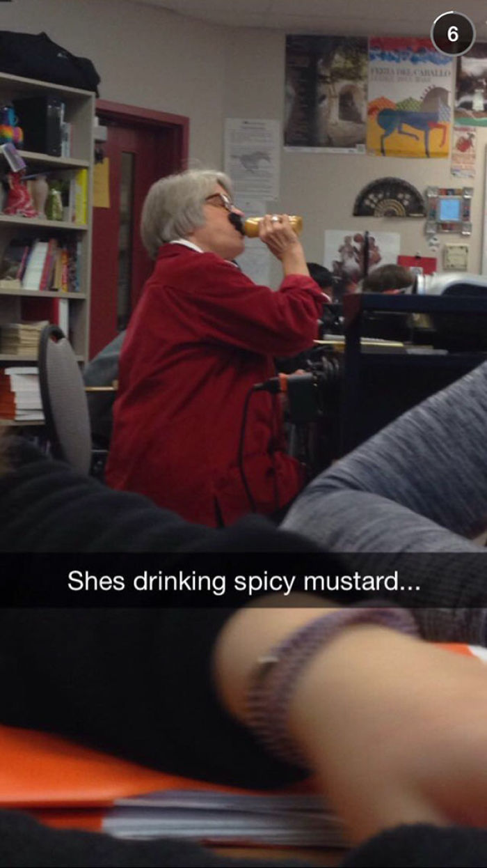 Person in a red jacket drinking mustard from a bottle, surrounded by books, showing carefree attitude.