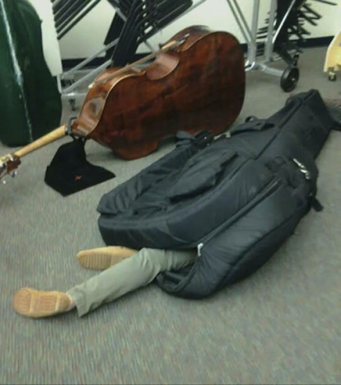 Person nonchalantly lying inside a large instrument case, showing indifference.