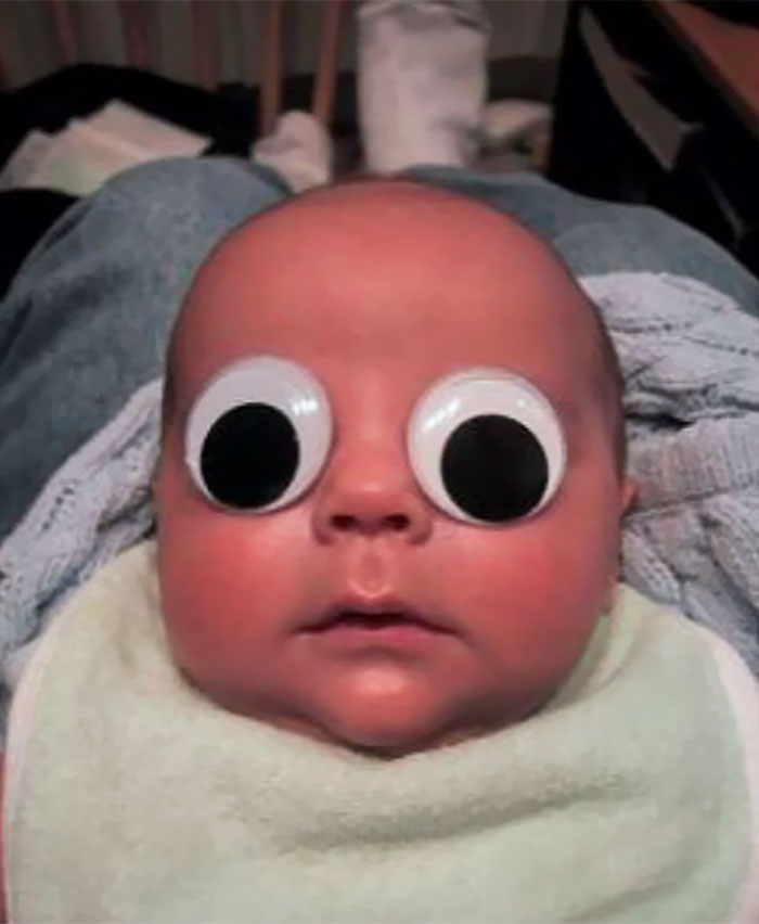 Baby with googly eyes taped on, showcasing dad's humor at another level.