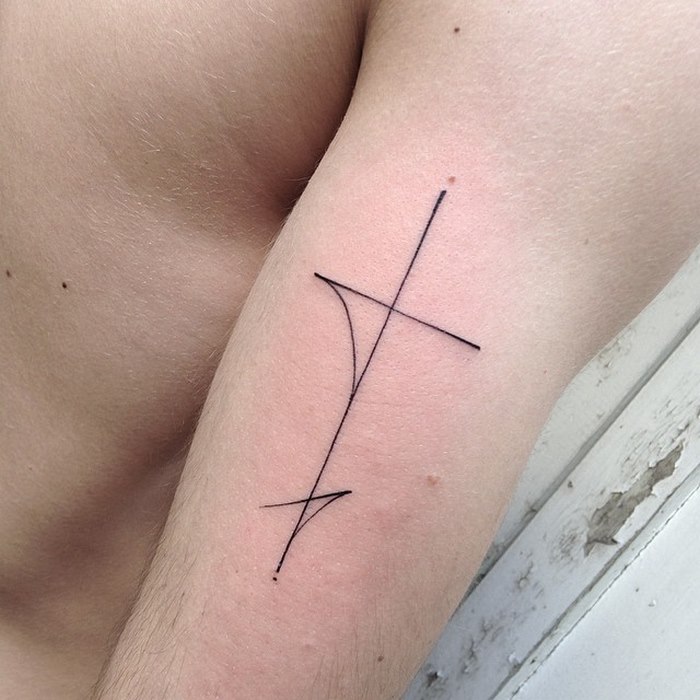 Minimalist typographic tattoo by Léo Gavaggio on arm, showcasing delicate and sophisticated line work.