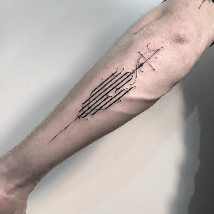 Delicate typographic tattoo by Léo Gavaggio on a forearm showcasing intricate line work and sophistication.