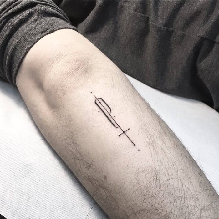 Minimalist typographic tattoo on forearm by Léo Gavaggio, featuring delicate line work and sophisticated design.