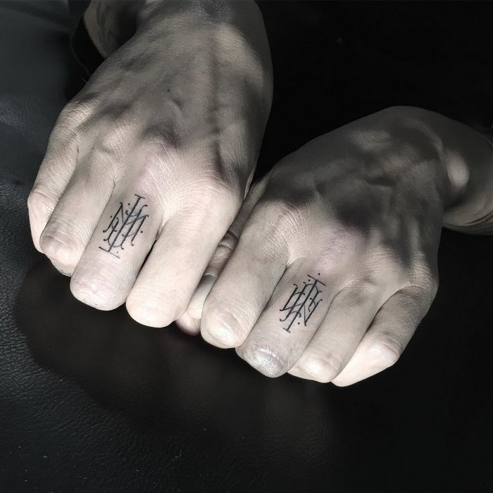 Delicate and sophisticated typographic tattoos on knuckles by Léo Gavaggio.