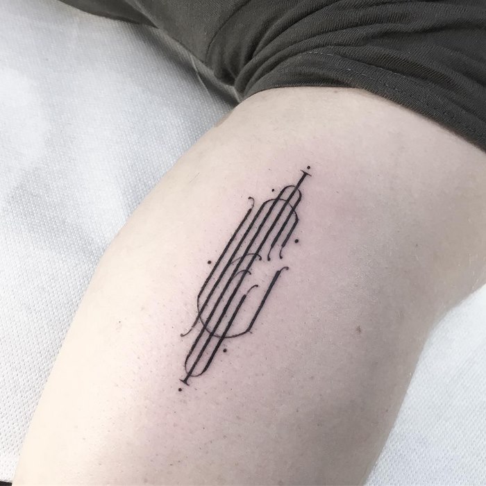 Delicate typographic tattoo by Léo Gavaggio on a person's arm, featuring intricate lines and dots.