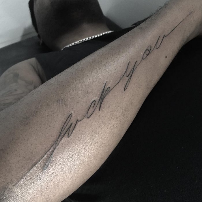 Delicate typographic tattoo on forearm, featuring cursive lettering by Léo Gavaggio.