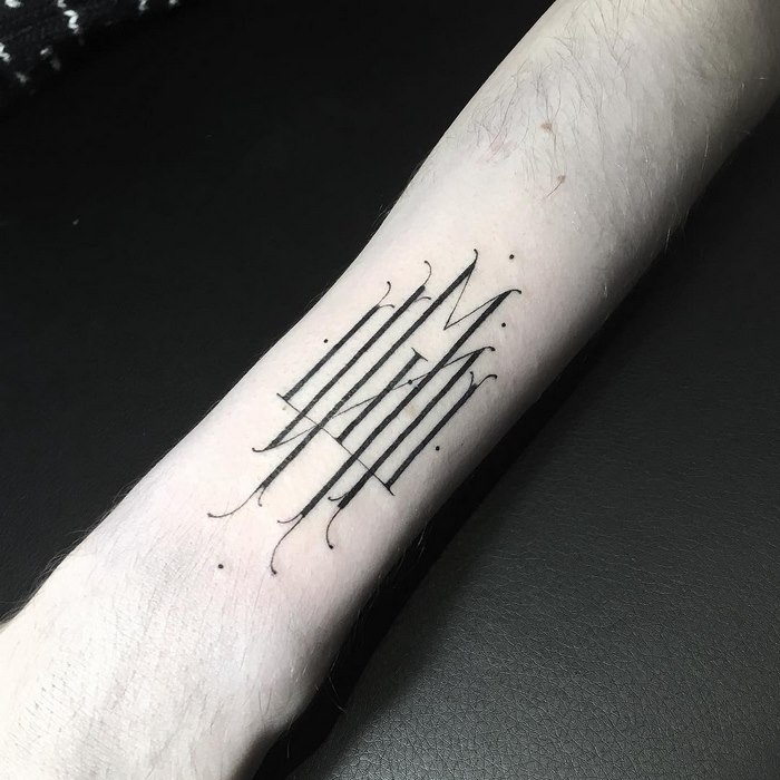 Delicate typographic tattoo by Léo Gavaggio, featuring intricate lines on a forearm.