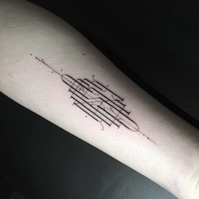 Intricate typographic tattoo by Léo Gavaggio on a forearm, featuring delicate and sophisticated linework.