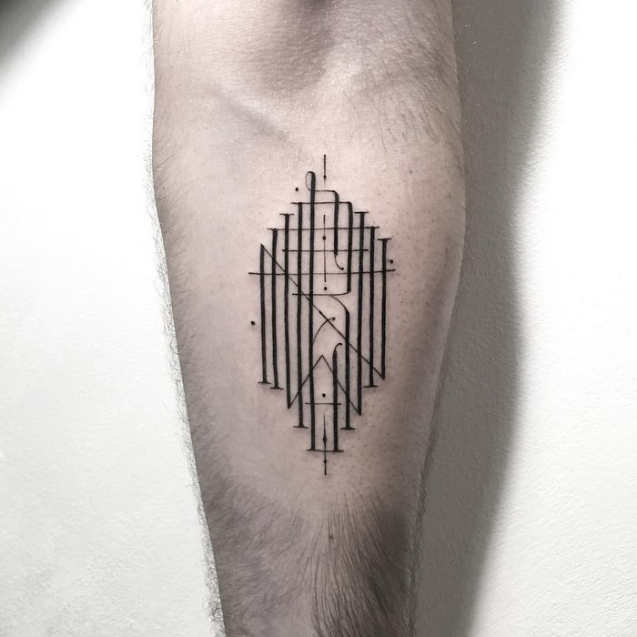Delicate and sophisticated typographic tattoo on forearm featuring abstract line design and geometric shapes.