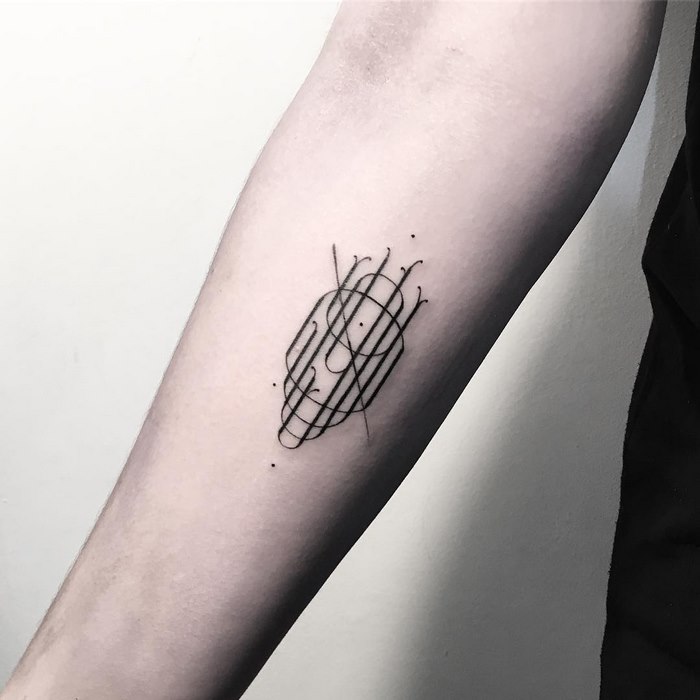 Delicate typographic tattoo on forearm with intersecting lines and dots, showcasing sophisticated design by Léo Gavaggio.