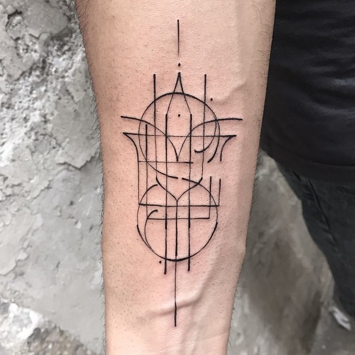 Delicate typographic tattoo by Léo Gavaggio, featuring geometric and sophisticated linework on a forearm.