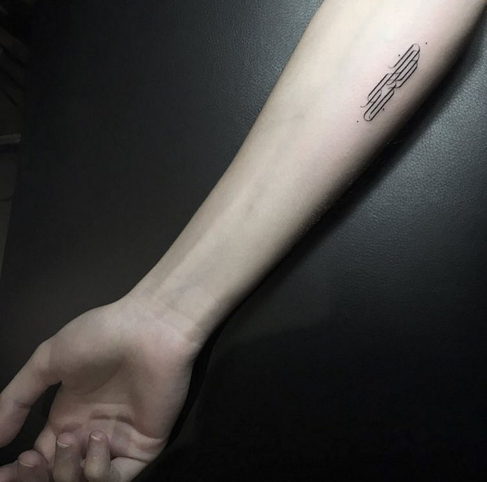 Delicate typographic tattoo on forearm, showcasing elegant design.