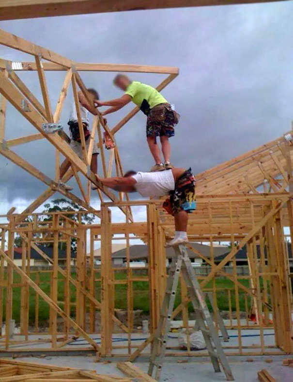 Men in precarious construction setup, demonstrating safety risks on a ladder, illustrating why women live longer.