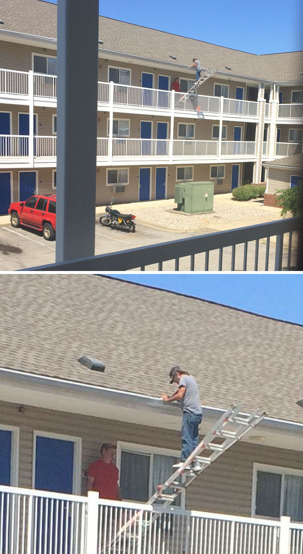 Man balancing on a ladder precariously positioned between two balconies, illustrating risky behavior.