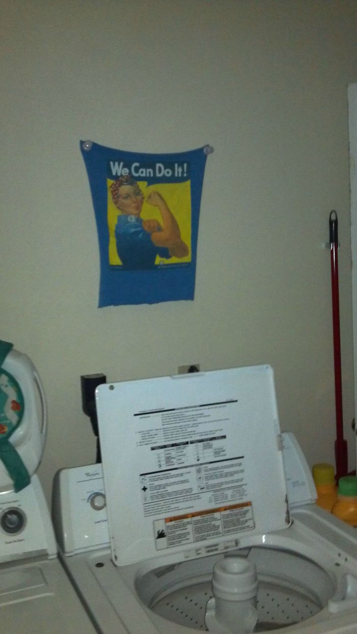 Laundry room with a “We Can Do It!” poster above a washing machine.