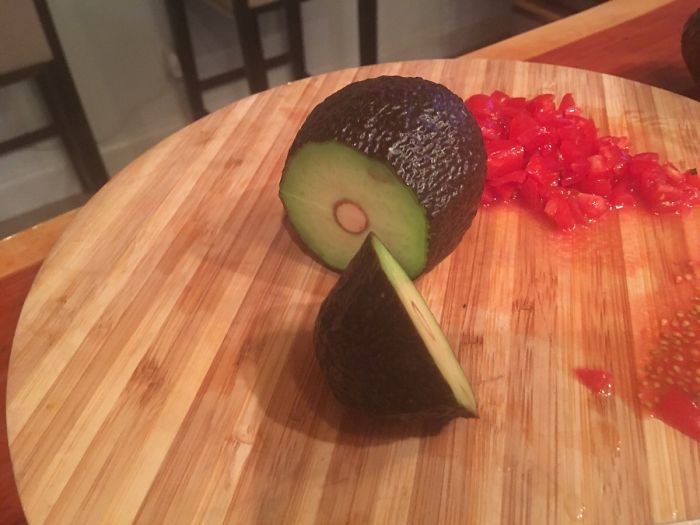 Avocado cut incorrectly with pit intact, showcasing a common mistake.
