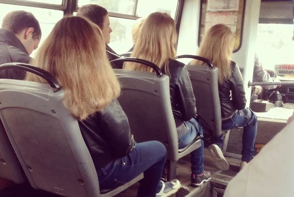 Three girls sitting in the bus and wearing same clothes