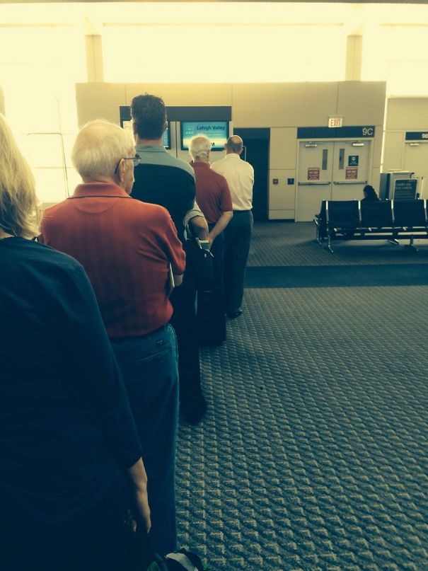 Two mans standing in the line and wearing same clothes