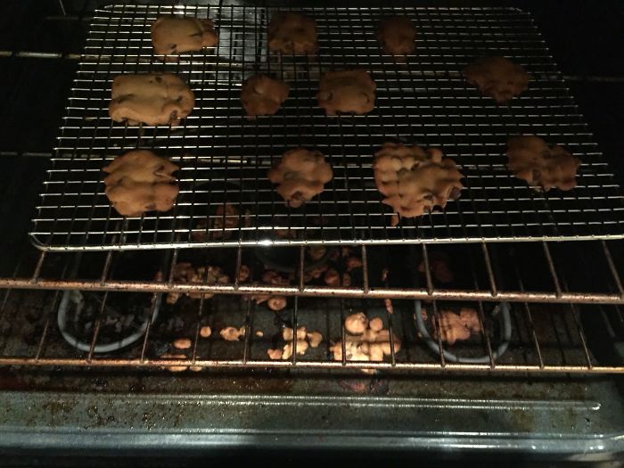Cookies on a cooling rack in the oven with crumbs scattered; dating an idiot moment captured.