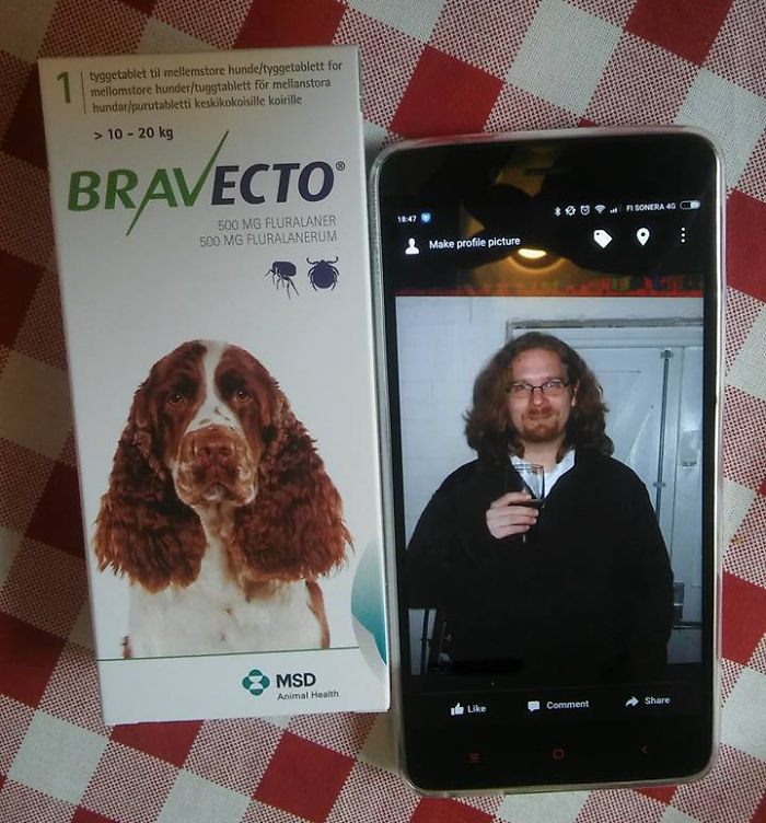 Dog medication box beside a smartphone displaying a man holding a drink, with a humorous twist inspired by hilarious wives.