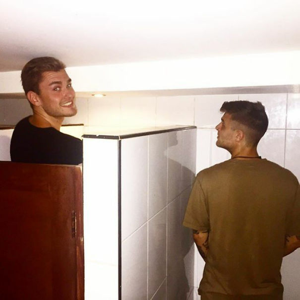 Two tall people struggling to fit in a low-ceiling bathroom, highlighting everyday struggles of tall people humorously.