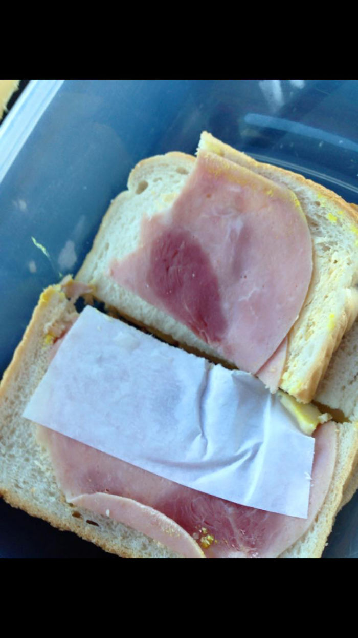 A funny sandwich with a slice of ham and paper, showcasing a hilarious wife's prank.
