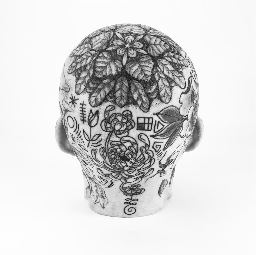 Tattoo culture writer's intricate head tattoos showcase creative designs and floral patterns, viewed from the back.