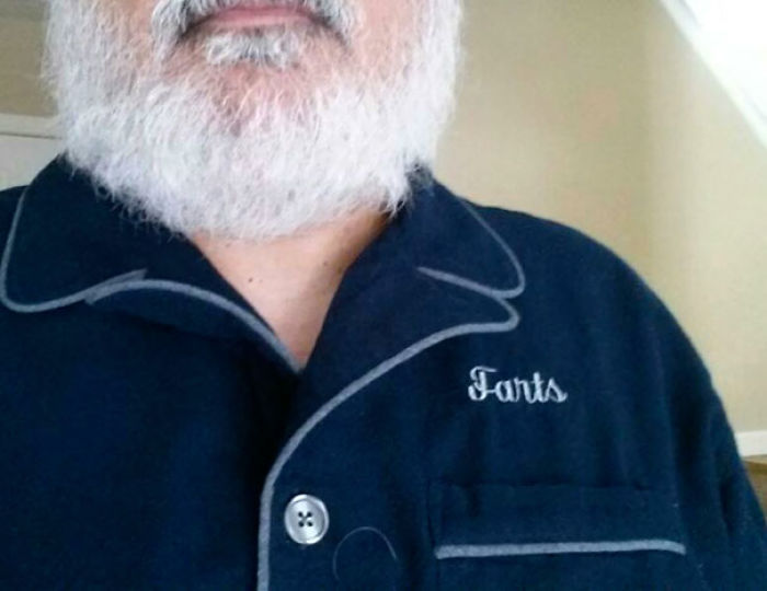 Man with a beard wearing a blue shirt labeled "Farts," showcasing a funny side wives might secretly appreciate.