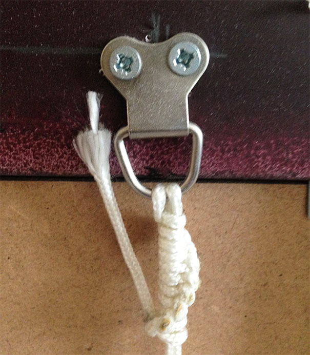 Metal hanger attachment with screws resembling a face and a rope creating a funny example of pareidolia in everyday objects.