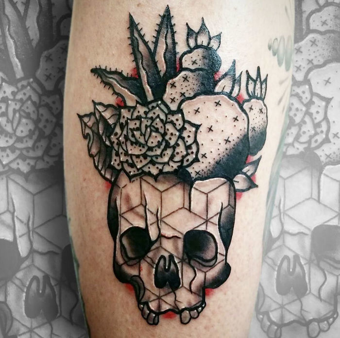 Succulent tattoo featuring a geometric skull with cactus and succulent plants on skin.