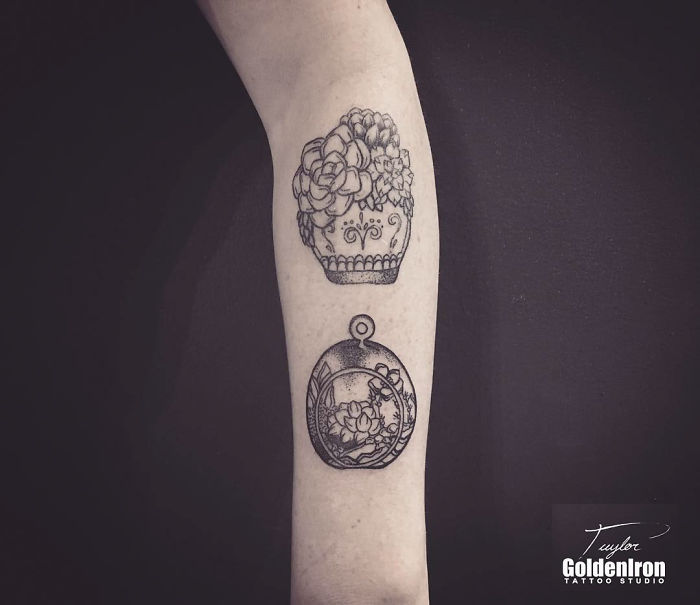 Succulent tattoo design on forearm featuring a pot and pendant, showcasing intricate details and creativity.
