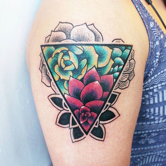 Colorful succulent tattoo on an arm, featuring a geometric design with vibrant flowers and leaves.
