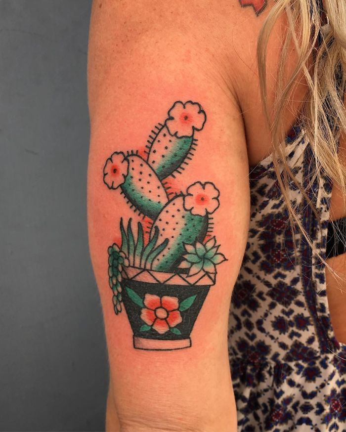 Succulent tattoo featuring a vibrant cactus and flowers on arm, perfect for succulent enthusiasts.