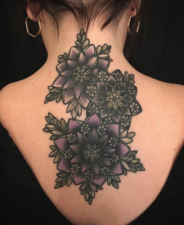 Back tattoo featuring intricate succulent designs in purple and green hues.