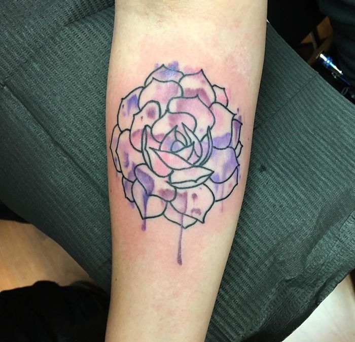 Purple succulent tattoo on forearm, showcasing detailed petals and shading.